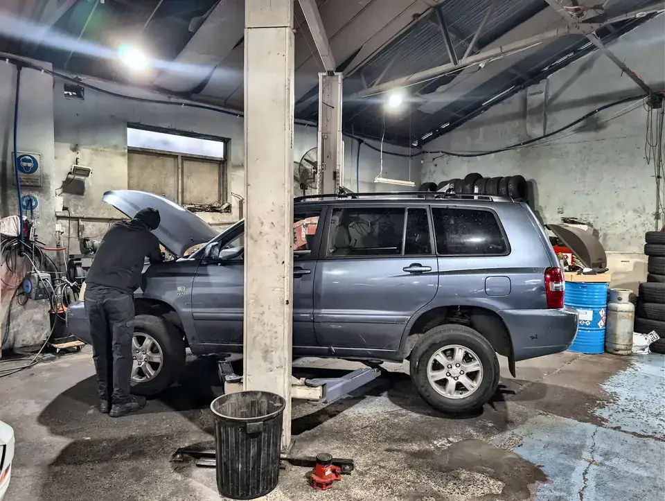 Mechanic working on a Toyota four-wheel drive on a two-post hoist