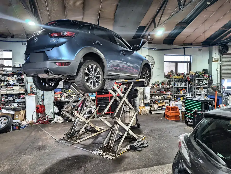 SUV raised on a scissor lift for underbody work