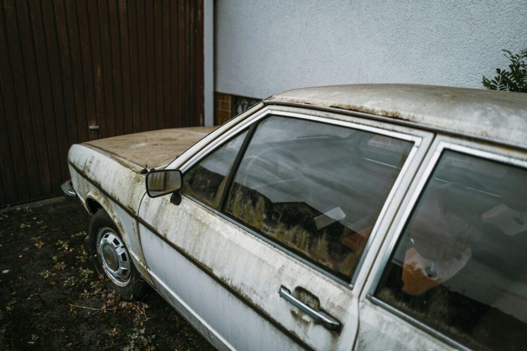 Dusty old sedan that has been parked for a long time