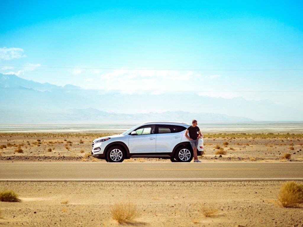 White SUV parked on a hot, sunny desert road