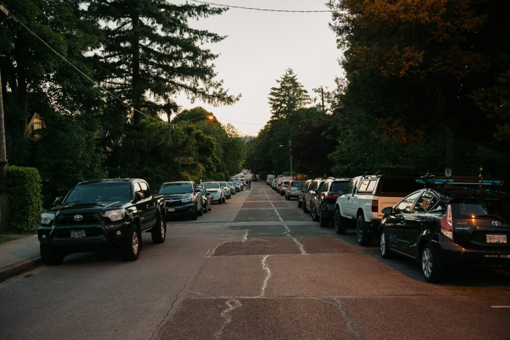 Suburban street lined with trees and parked cars