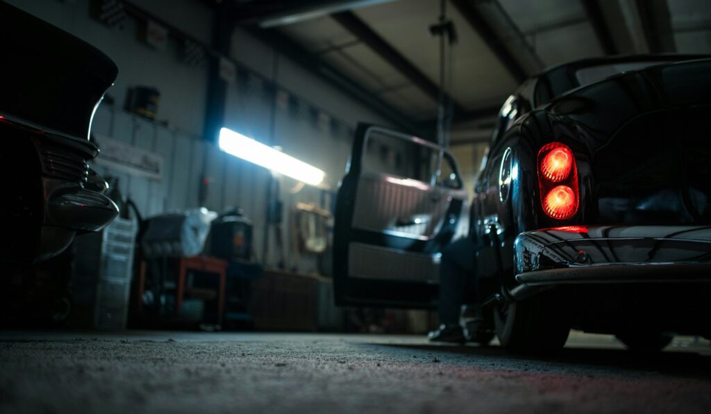 Car in a workshop bay with its tail lights on